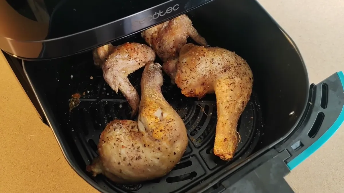 Cuisses et ailes de poulet épicées et dorées dans la cuve du Cecotec Cecofry 5500 Pro