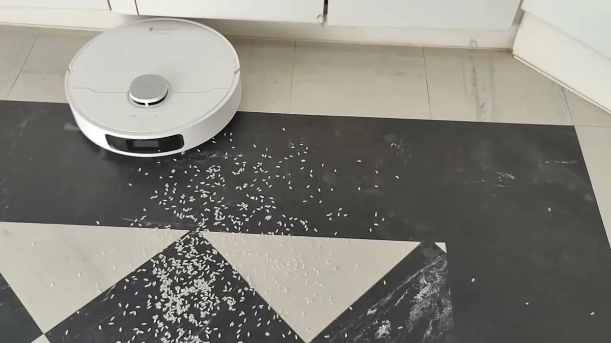 Le Dreame L10 Prime aspire des grains de riz répandus sur un carrelage noir et blanc