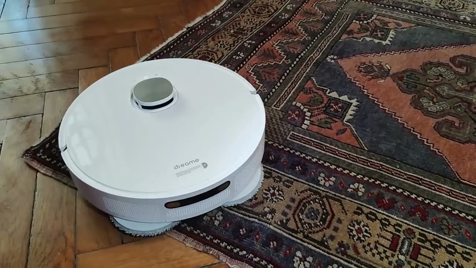 Le robot aspirateur laveur Dreame L10 Prime sur un tapis posé sur parquet