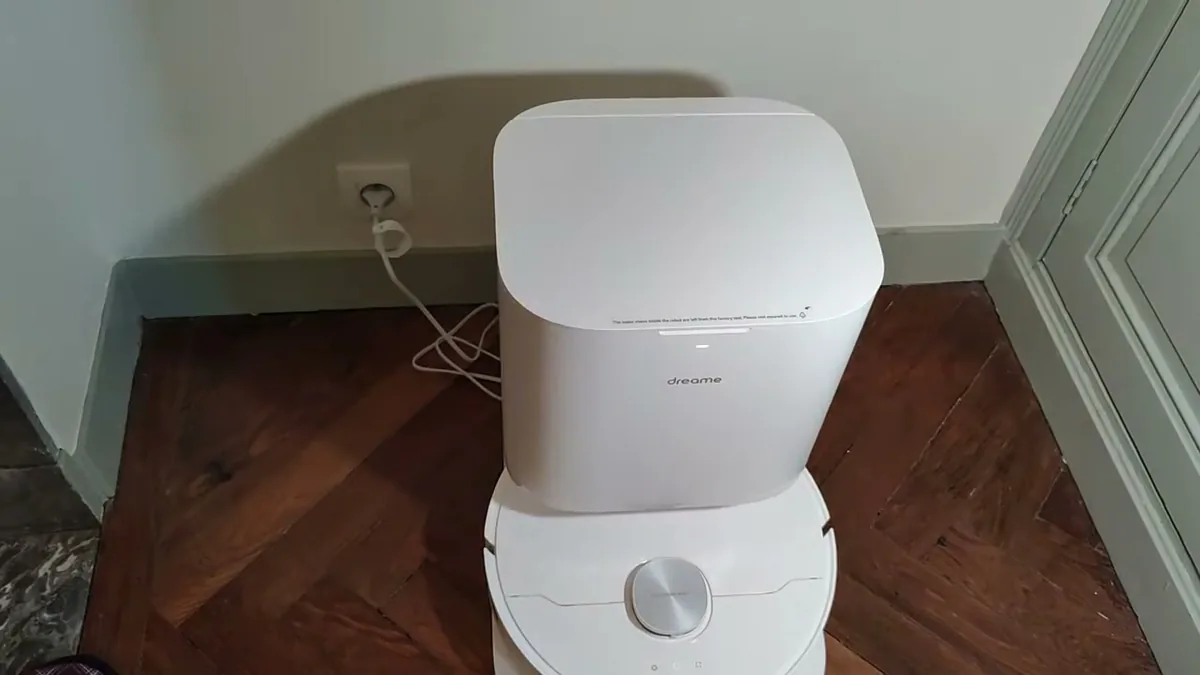 Le Dreame L10 Prime à sa station de nettoyage blanche, réservoirs d'eau propre et d'eau sale