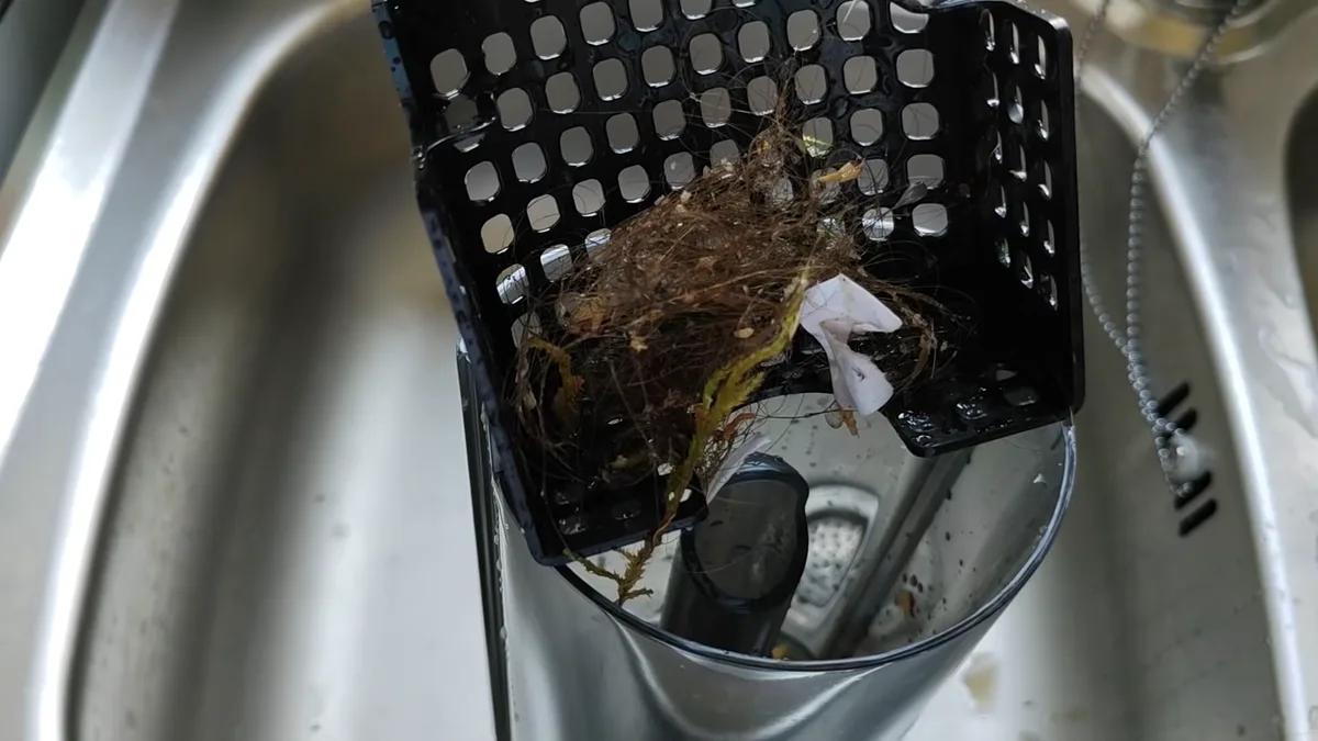 Vidange du réservoir d'eaux sales du Dreame T16 Pro Heat : cheveux et débris retenus dans le panier filtrant