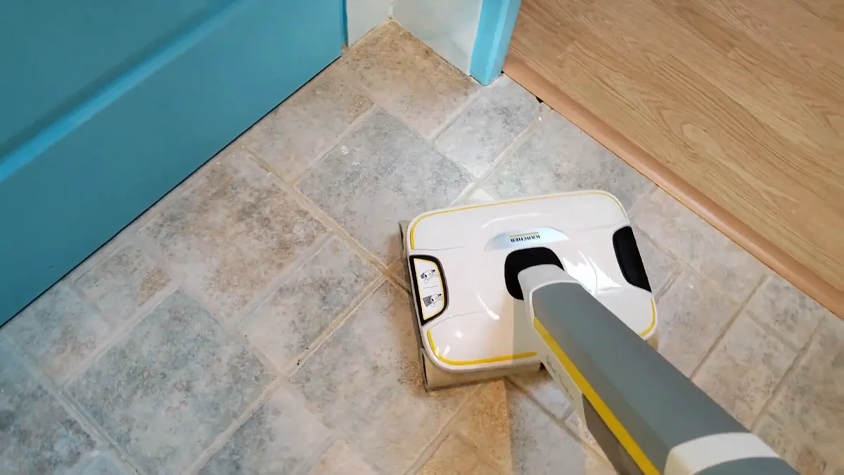 Le Kärcher FC 8 nettoie un carrelage antidérapant de salle de bain jusqu'au bord de la porte