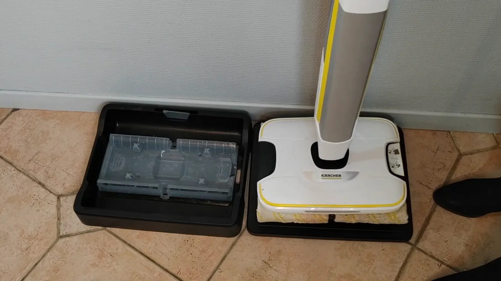 Le nettoyeur de sols Kärcher FC 8 Smart Signature Line posé sur son socle, à côté du bac d'autonettoyage
