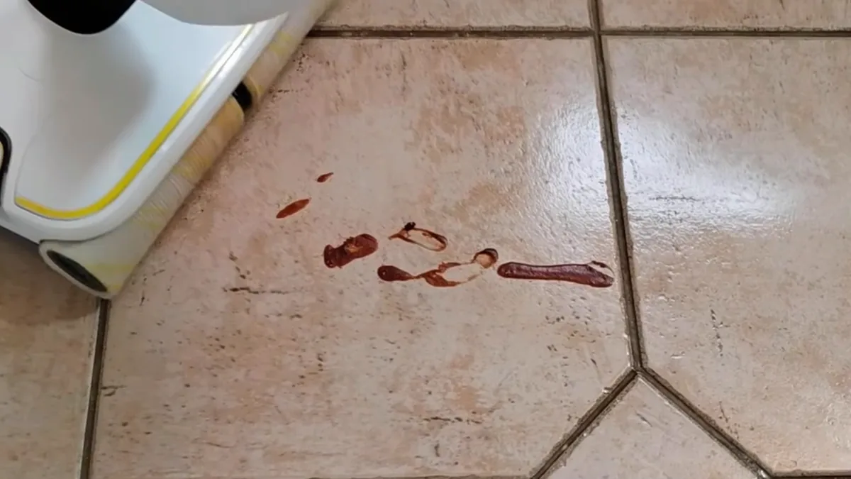 Tache de ketchup séchée depuis la veille sur un carrelage, face à la tête du Kärcher FC 8