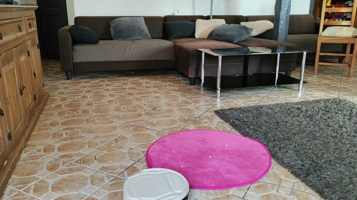 Le Lefant M210P bute contre un tapis rose fin pour enfant posé sur le carrelage du salon